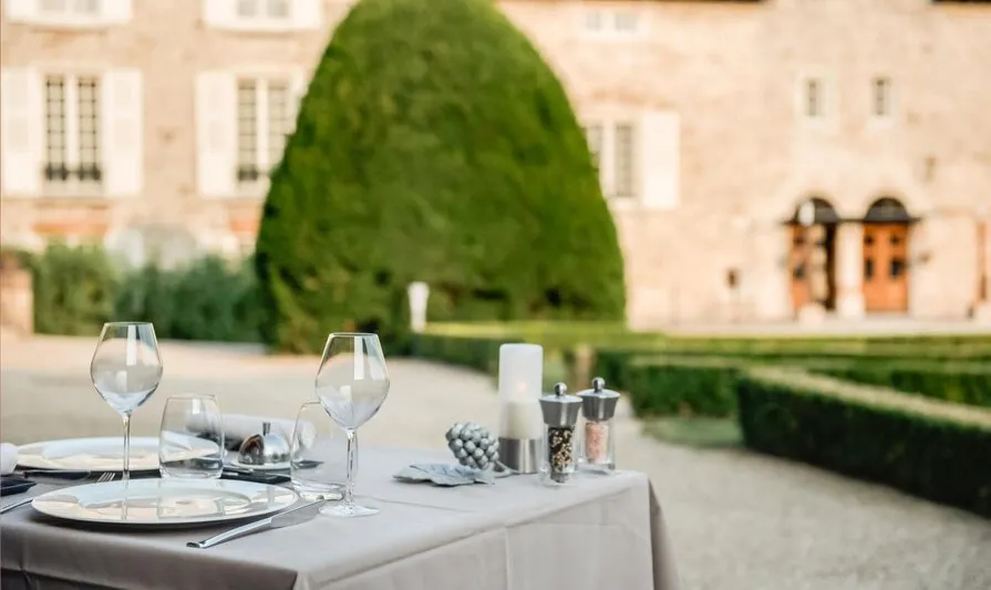 Une table dressée au jardin de La Table de Besseuil, devant la façade en pierre