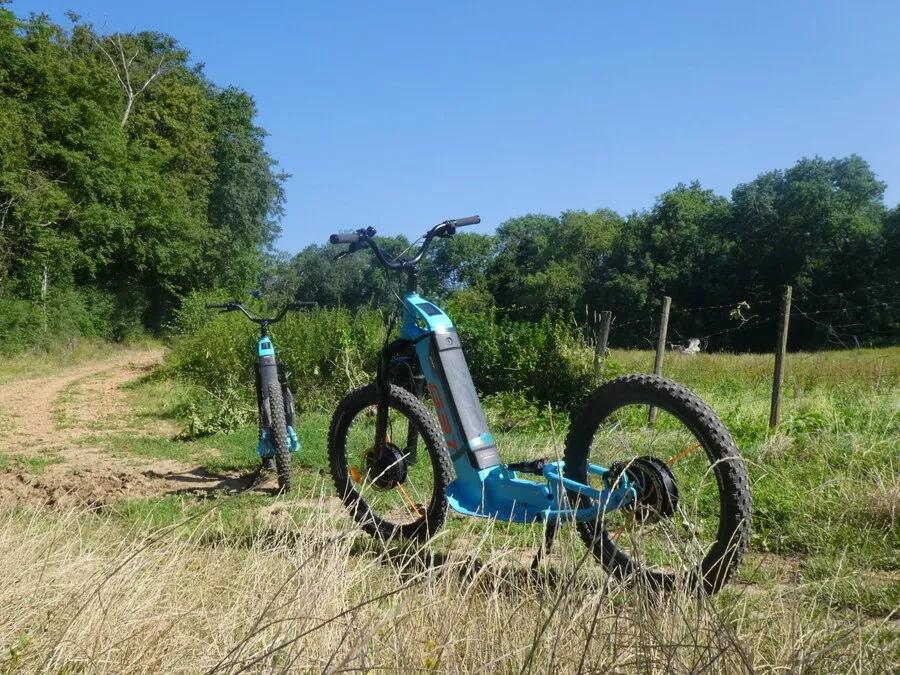 Deux trottinettes électriques tout terrain au bord d’un chemin