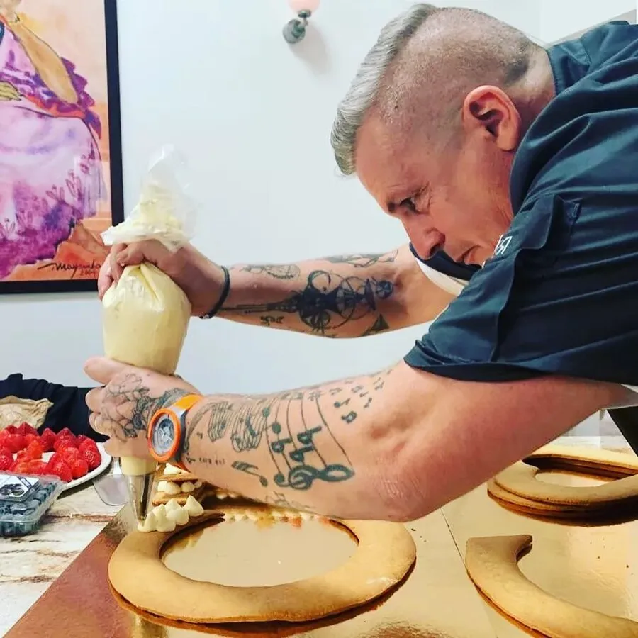 Un chef garnit un dessert à la poche