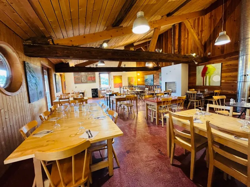 La salle du Pain sur la Table, ses tables en bois clair sous la charpente apparente