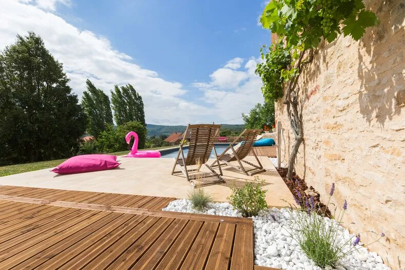 La terrasse au bord de la piscine, transats, coussin rose et flamant gonflable