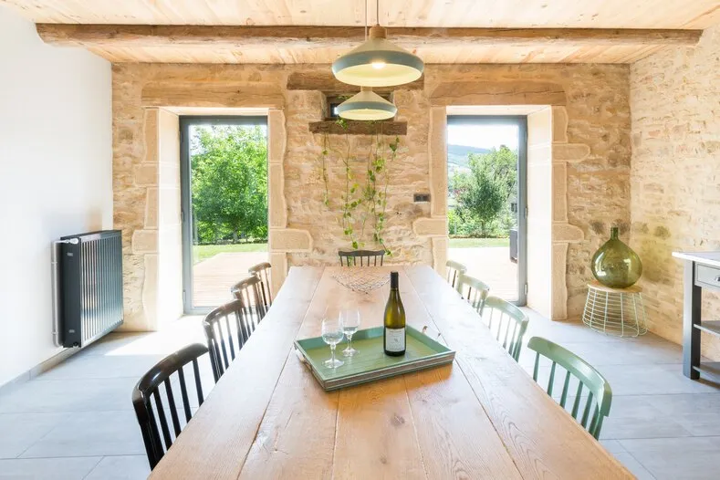 La grande table en bois, une bouteille et des verres