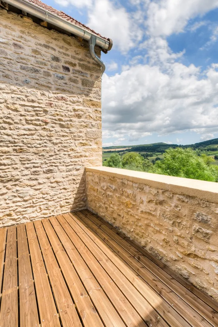 La terrasse du Pigeonnier, son parapet en pierre et la vue sur les vallons