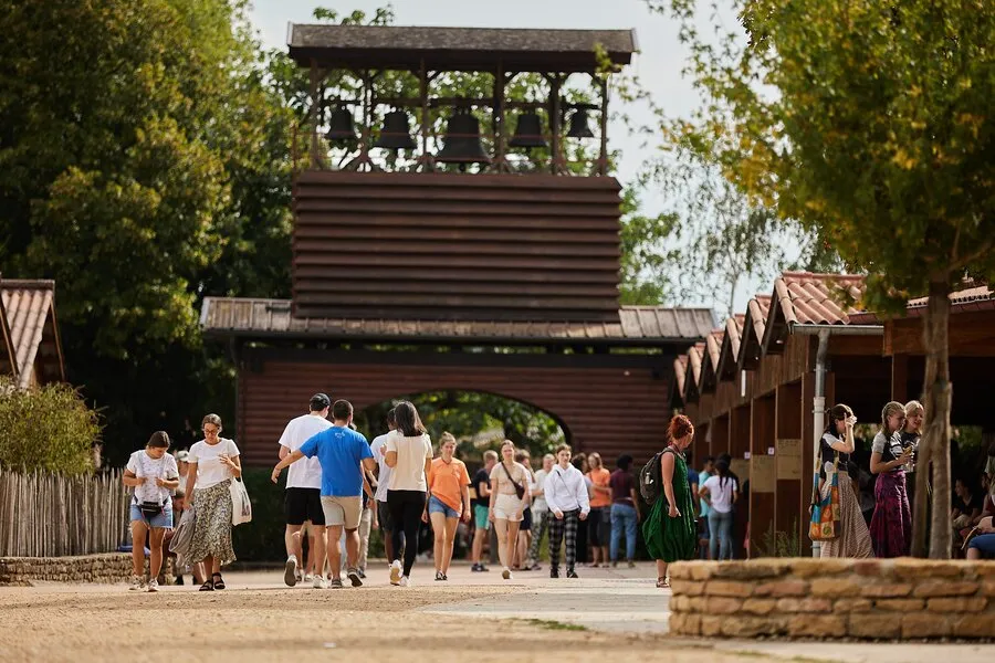 Des visiteurs à Taizé, devant le clocher en bois